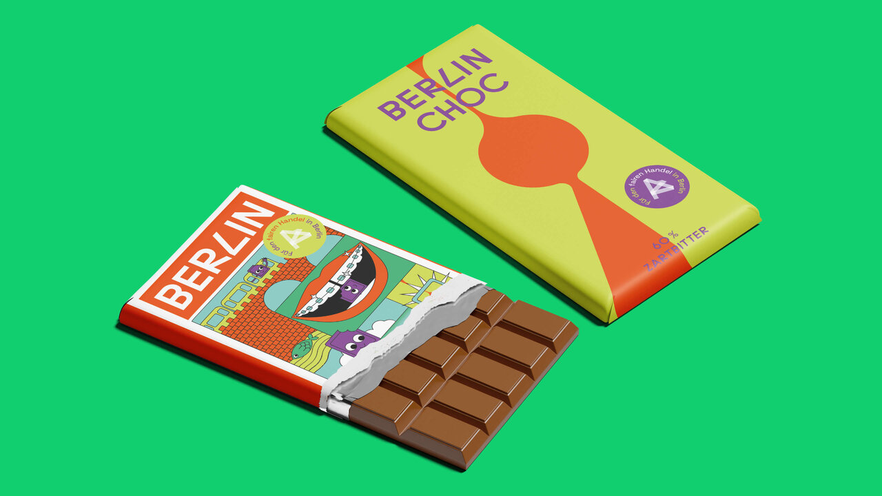Zwei fair gehandelte Bio-Schokoladentafeln von Berlin Choc in knalligen Farben vor einem gr&uuml;nen Hintergrund, eine Verpackung ge&ouml;ffnet, die andere geschlossen, mit grafischen Designelementen in Rot, Gelb und Orange.