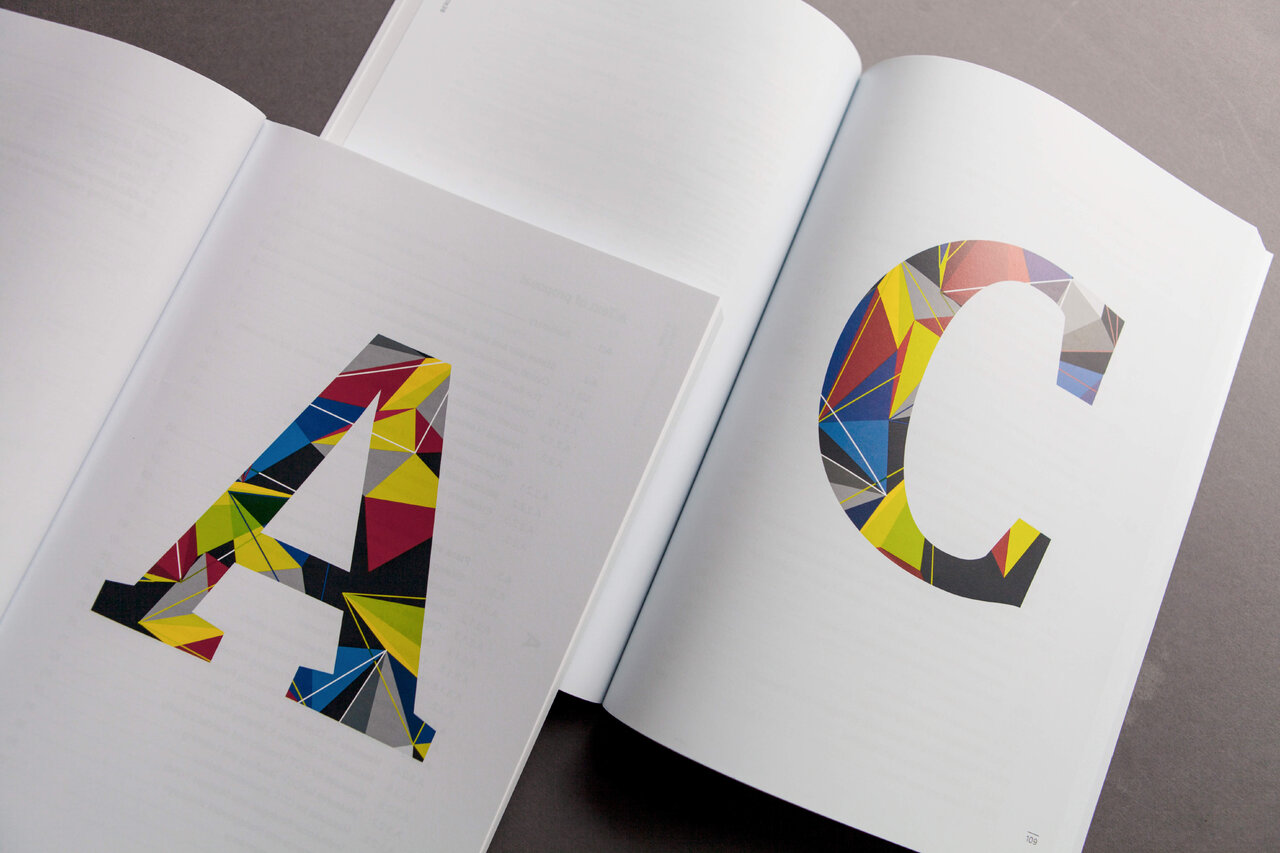 Zwei grafische Buchstaben A und C in einem aufgeschlagenen Buch, die mit geometrischen Formen in kr&auml;ftigen Farben wie Gelb, Blau, Rot und Rosa gestaltet sind, pr&auml;sentieren ein abstraktes und modernes Design.