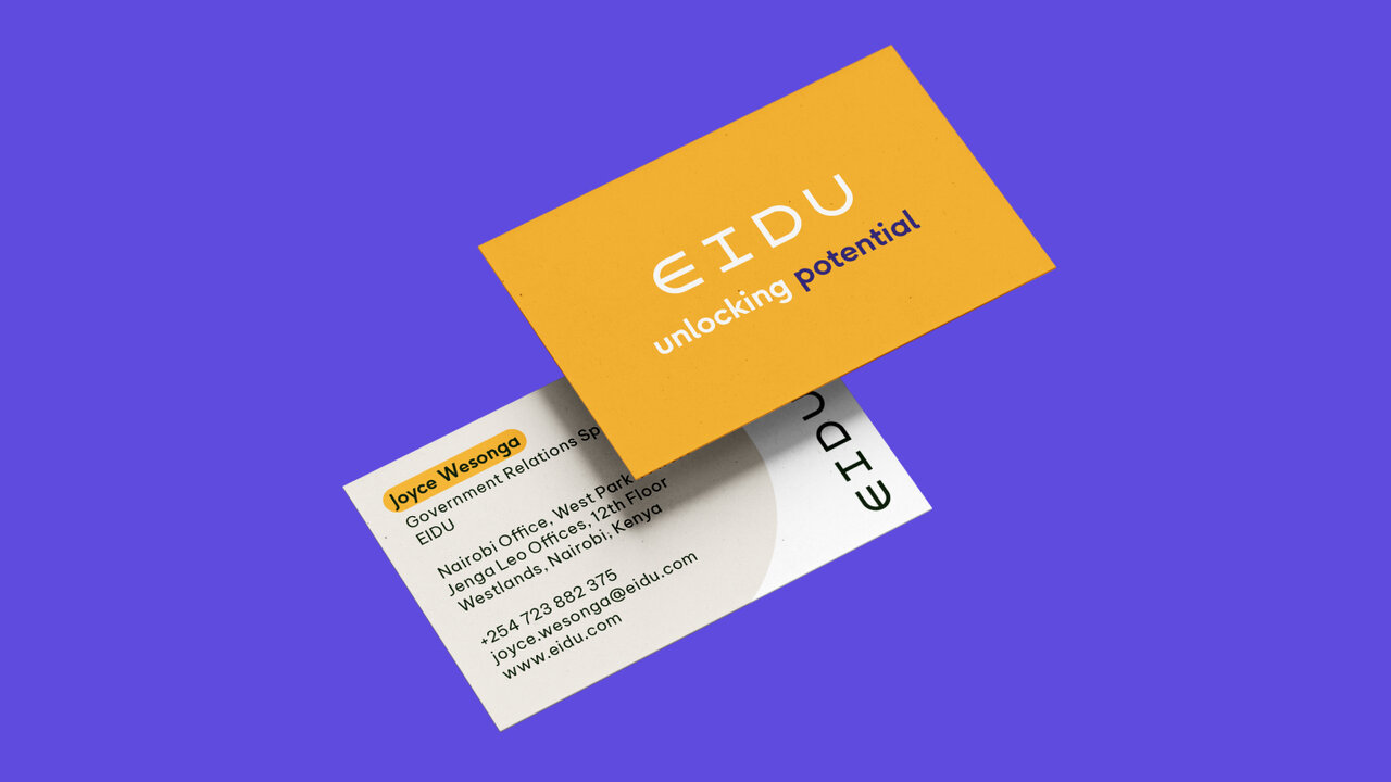 Zwei gelb-wei&szlig;e Visitenkarten von EIDU, leicht &uuml;bereinander gelegt, vor einem violetten Hintergrund. Die Karten zeigen das Logo und Kontaktinformationen in klarem, modernem Design.