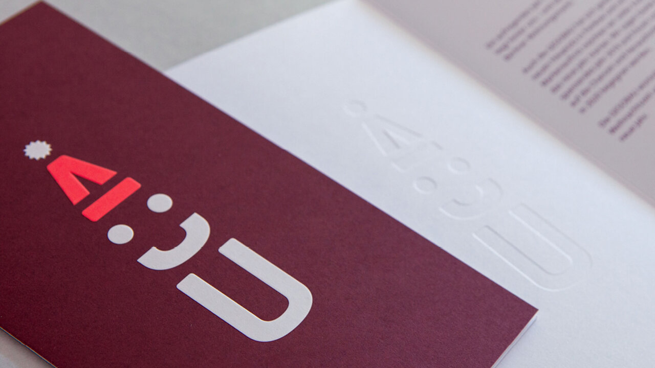 Logodesign einer Weihnachtskarte auf bordeauxrotem Hintergrund, mit klarer typografischer Gestaltung.