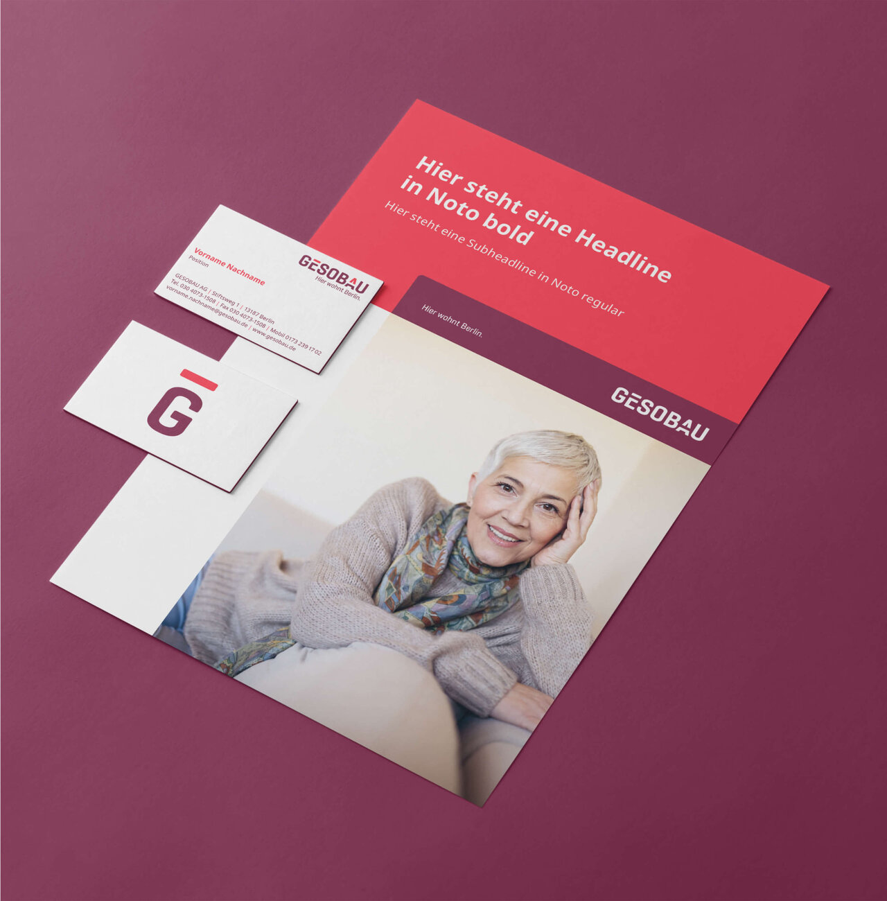 Eine Muster-Mappe der GESOBAU. Sie zeigt auf dem Cover eine &auml;ltere Frau mit kurzen blonden Haaren, sie l&auml;chelt entspannt in einem grauen Pullover und buntem Schal. Sie liegt gem&uuml;tlich und lehnt sich an. Au&szlig;erdem sind Muster-Visitenkarten der GESOBAU zu sehen.