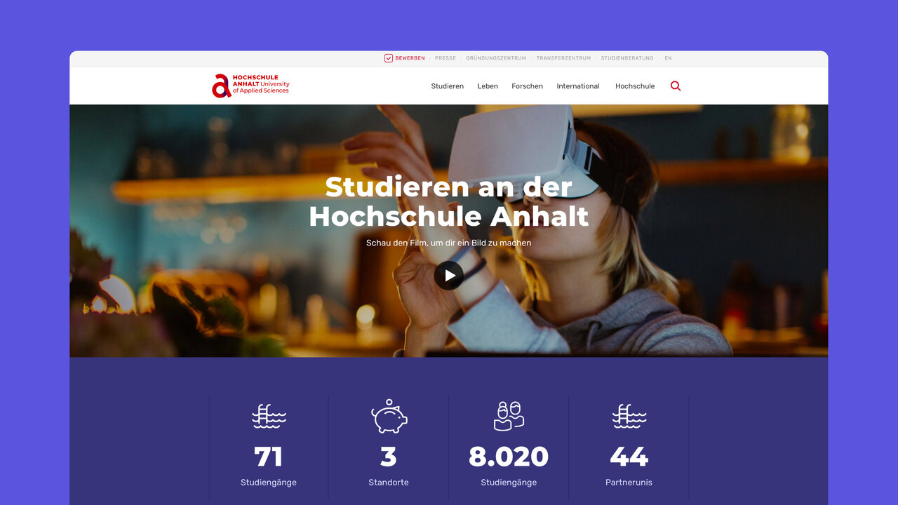 Website-Screenshot der Hochschule Anhalt mit unscharfem Hintergrund und VR-Brille, zeigt Website-Header mit Statistiken zu Studieng&auml;ngen, Standorten und Studierendenzahlen in blau-lila Farbschema.