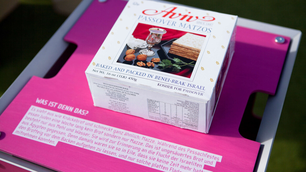 Eine wei&szlig;e Verpackungsbox von "Chiro" auf einer pinkfarbenen Unterlage, die offensichtlich Teil eines Ausstellungs- oder Kommunikationsdesignprojekts ist.