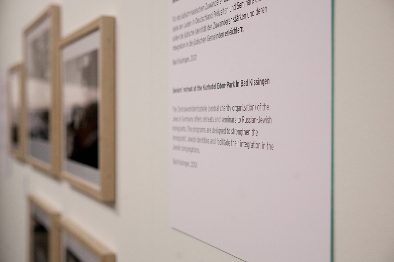 Detailaufnahme einer Ausstellungswand mit gerahmten Fotos und erl&auml;uterndem Textblock, die Teil der Projektpublikation zu Michael Kerstgens' Langzeitprojekt &uuml;ber j&uuml;disches Leben in Deutschland seit 1992 ist.