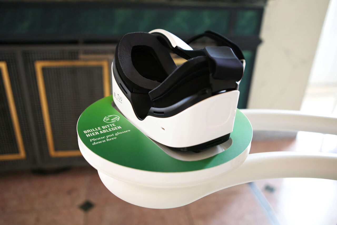 Eine wei&szlig;-schwarze VR-Brille auf einem gr&uuml;nen Sockel, die Teil eines innovativen VR-Konzertprojekts von Studio Good f&uuml;r das Konzerthaus Berlin ist, welches Mozarts Jupiter-Sinfonie durch interaktive visuelle Elemente erlebbar macht.