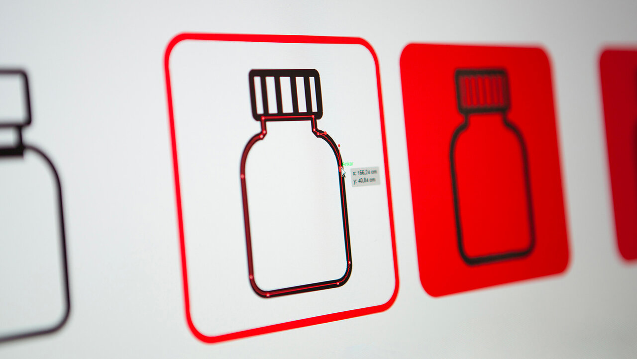 Stilisierte Darstellung einer Medizinflasche in wei&szlig; und rot mit quadratischem Rahmen, symbolisiert medizinische Versorgung und Hilfsbereitschaft.