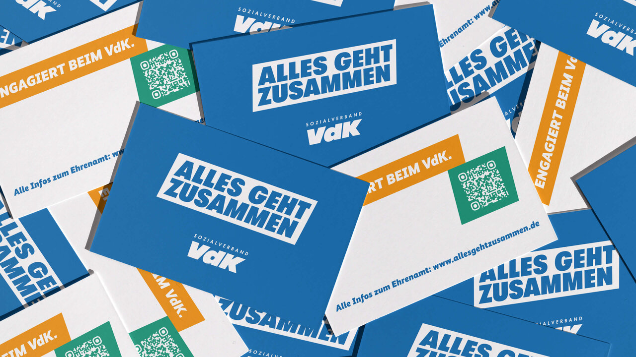 &Uuml;berlappende Postkarten in Blau, Wei&szlig; und Orange mit dem Slogan "Alles geht zusammen" und VdK-Logo, die eine Kampagne f&uuml;r Zusammenhalt und Inklusion darstellen.