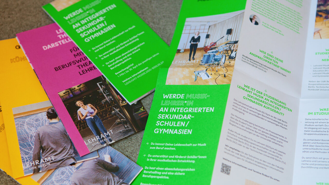 Verschiedene Brosch&uuml;ren und Informationsmaterialien in Gr&uuml;n, Pink und Gelb, die Studieninformationen der Universit&auml;t der K&uuml;nste Berlin f&uuml;r Lehramt pr&auml;sentieren, mit gestalteten Layouts und Fotografien.