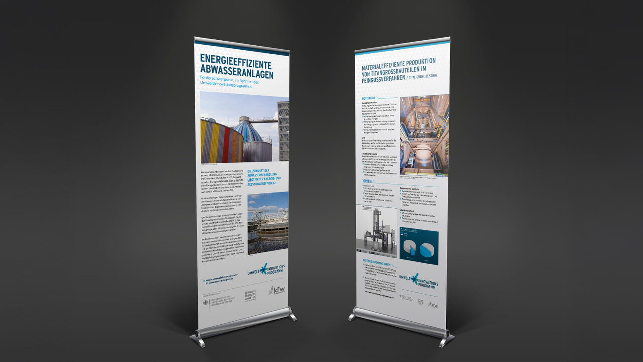 Zwei Roll-up-Banner mit technischen Informationen und Grafiken zu energieeffizienten Anlagendesigns, pr&auml;sentiert vor einem dunklen Hintergrund, die Informationen in blau-grauer Farbpalette gehalten.